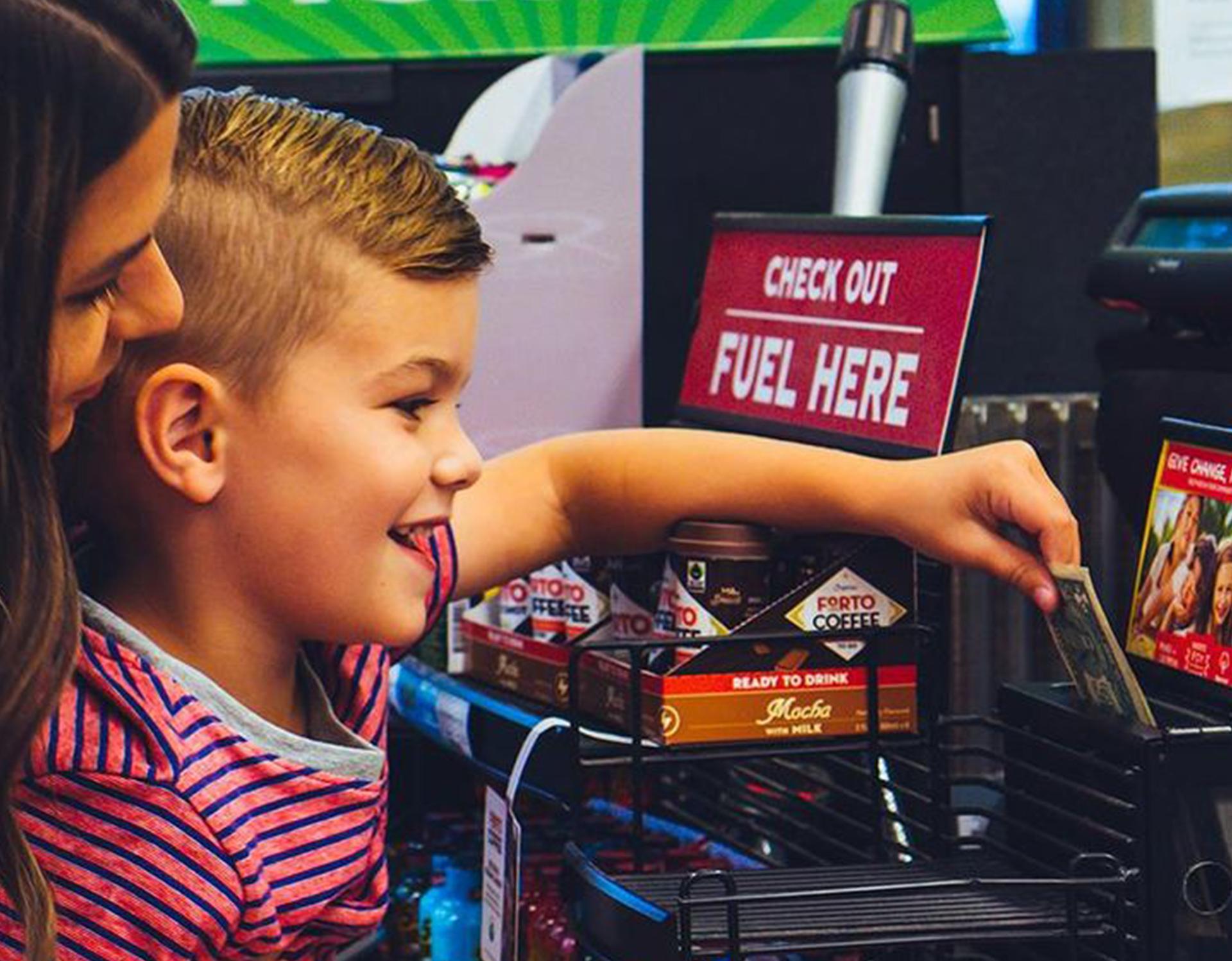 boy donating a dollar to a sheetz charity in-store