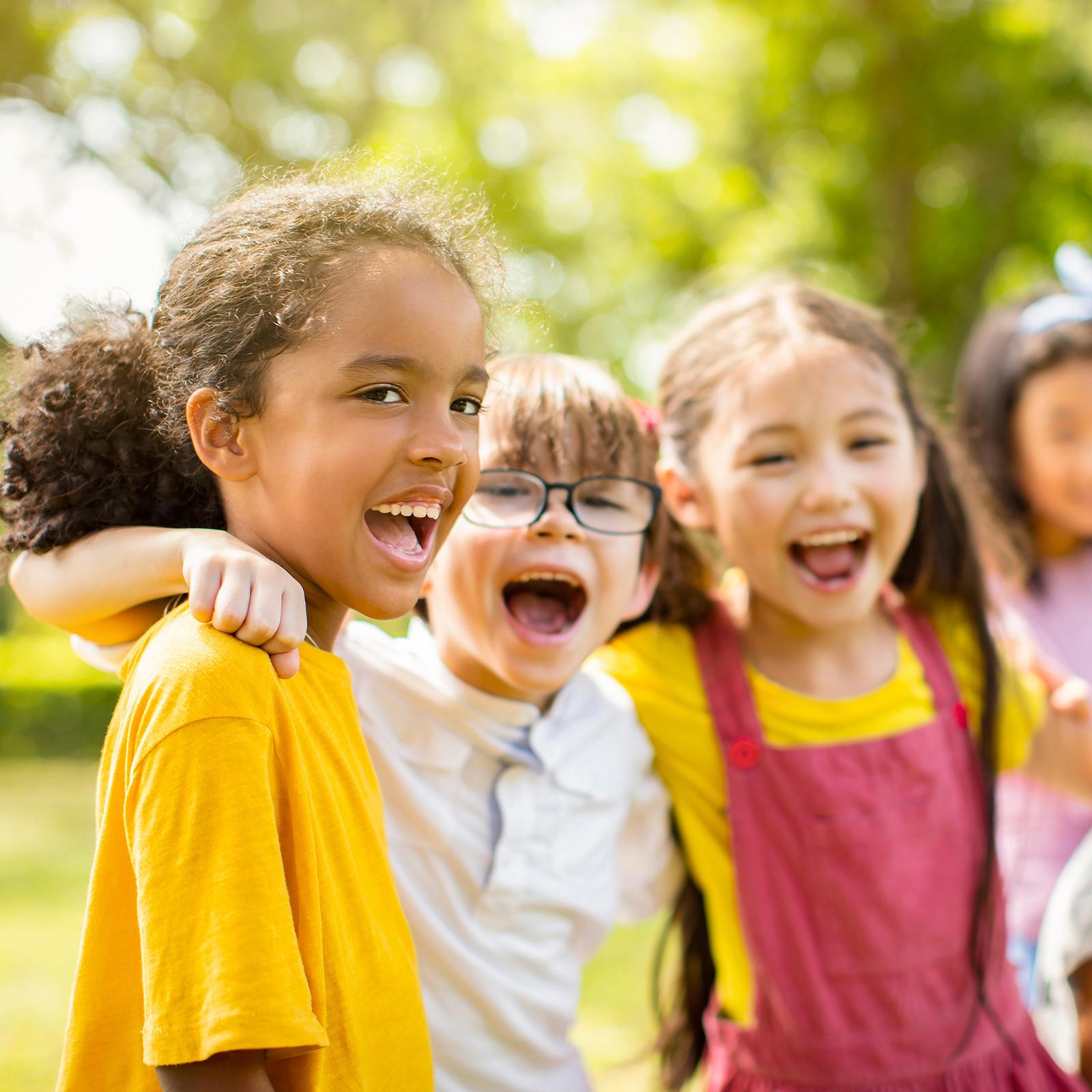 group of kids smiling in an outdoor setting